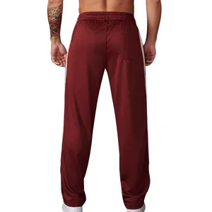Rear view detail of men's burgundy sweatpants with white side stripes and loose fit