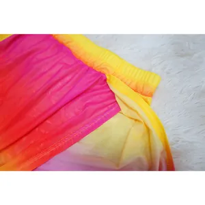 Close-up detail of gradient pink and yellow mesh fabric on a high-slit skirt waistband.