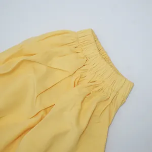 Detailed view of a yellow plus-size dress showing the comfortable elastic waistband design.