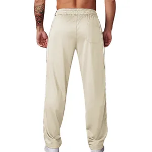 Back view of beige men's loose casual pants with white side stripes and elastic waist