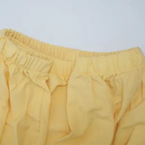 Macro detail of the comfortable elastic waistband on a yellow summer batwing sleeve dress.