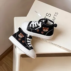 Dettaglio di eleganti scarpe da ginnastica per bambini con ricamo a forma di orso.