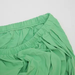 Detailed close-up showing the elasticated waistband texture of a green plus-size dress