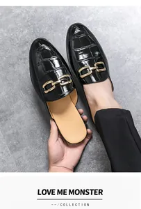 Detailed view of men's black crocodile embossed leather loafers with elegant gold buckle