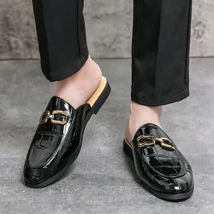 Fashionable men's crocodile-embossed black patent leather mules with decorative gold buckle