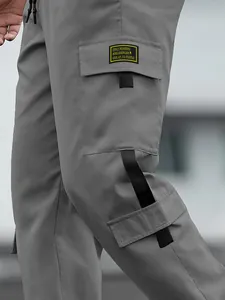 Men's grey multi-pocket cargo pants featuring a detailed pocket label and waist drawstring