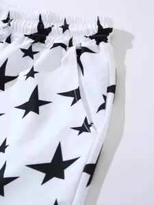 Close-up of white men's beach shorts with black star pattern and elastic waistband.