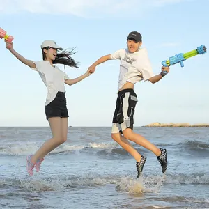 Coppia che salta sulla spiaggia indossando scarpe da acqua outdoor ad asciugatura rapida.
