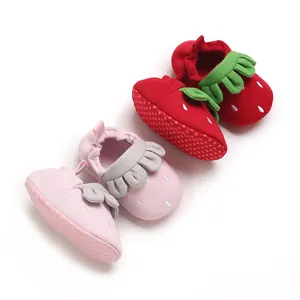 Primer plano de lindos zapatos para bebés con forma de fresa y suelas antideslizantes