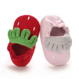 Primer plano de lindos zapatos de bebé con diseño de fresa en tela de algodón suave