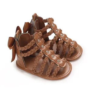 Detailansicht brauner Baby-Sandalen mit Schleife und geflochtenen Riemen aus PU-Leder