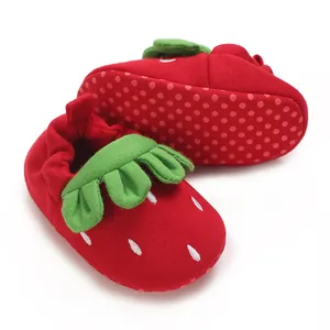 Detalle de zapatos suaves para bebé con diseño de fresa en color rojo