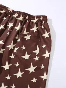 Detailed view of brown men's beach shorts featuring a cream star print and back pocket