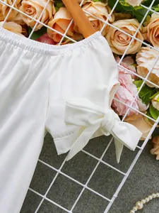 Primer plano detallado de la manga de un vestido blanco con hombros descubiertos y nudo elegante