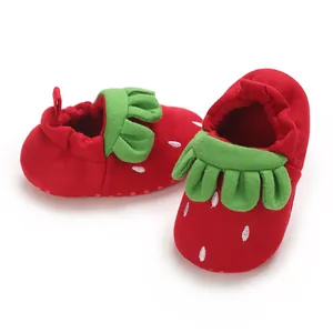 Detalle de zapatos de tela suaves para bebés con diseño de fresa roja muy infantil