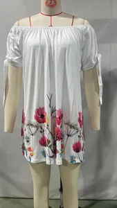 Detalle de vestido blanco de verano con hombros descubiertos, flores y lazos