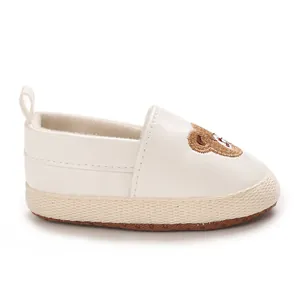 Vista lateral detallada de zapato para bebé blanco con lindo bordado de osito