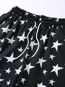 Close-up detail of the elastic waistband and white star pattern on black beach shorts