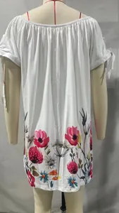 Vista detallada del estampado floral y nudo en la manga de este vestido blanco