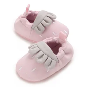 Detalle de zapatos de marcha suaves rosas para bebé con volantes grises y bordado