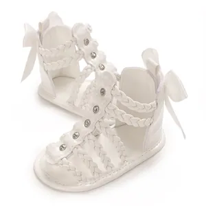 Detailansicht weißer Baby-Gladiatorensandalen mit Strasssteinen und Schleife hinten