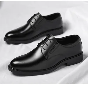 Primer plano de elegantes zapatos de vestir de cuero negro para hombre en tela blanca