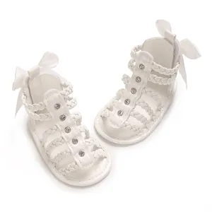 Elegante weiße Baby-Gladiatorensandalen mit geflochtenen Riemen, Strass und Schleifen.