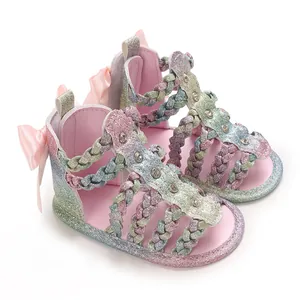 Detailansicht von rosa Glitzer Babysandalen mit geflochtenen Riemen.