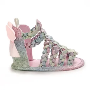 Seitenansicht von glitzernden Regenbogen-Babysandalen mit rosa Schleife und Zöpfen