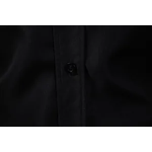 Macro view showing the black button and fine fabric texture on a formal men's shirt