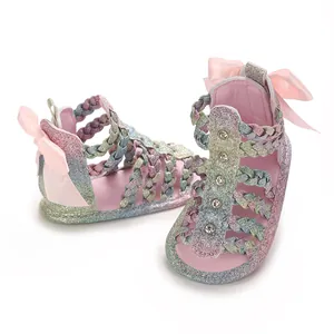 Detailansicht der Regenbogen-Glitzer-Babysandalen mit rosa Schleifen und Strass