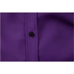 Macro detail of black button and premium textured purple fabric on a men's dress shirt.