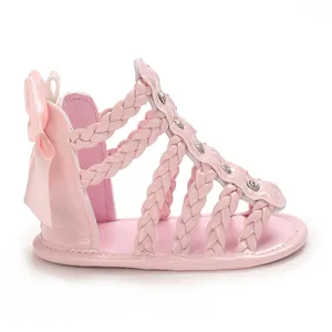 Detailansicht rosa Baby-Sandalen mit geflochtenen Riemen und Zierschleife an der Ferse
