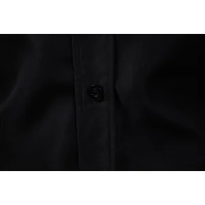 Close-up of the button and placket detail on a black long-sleeved shirt