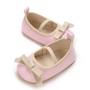 Close-up detail of pink baby princess shoes with elegant beige leather bow decoration