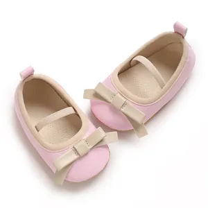 Close-up view of pink baby girl princess sandals with beige bow and elastic strap