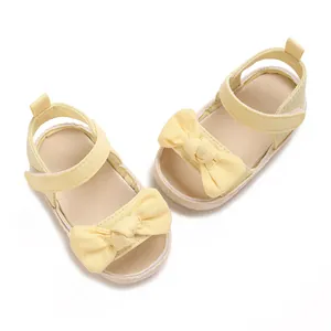 Vista superior de sandalias amarillo claro para bebé niña con lazo y correa ajustable