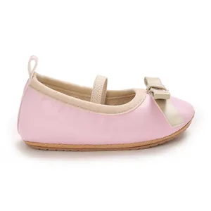 Soft pink baby princess flats with beige bow detail for infant girls' formal wear.