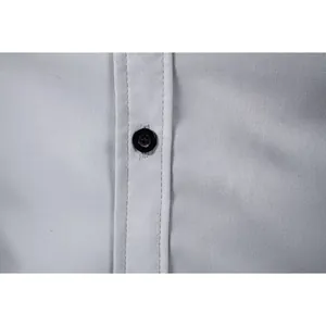 Close-up macro detail of black button and stitching on a light gray formal shirt