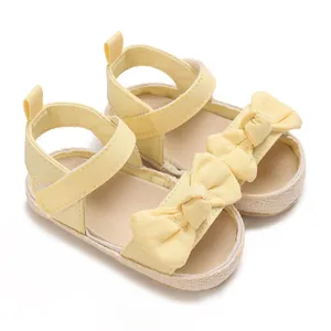 Primer plano de sandalias amarillas de verano para bebé con lazo suave y cierre de velcro