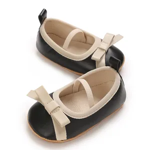 Detail shot of black and cream baby girl princess shoes featuring a soft bow and strap