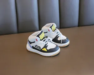 Detail view of children's high-top sneakers with color-block design and soft sole