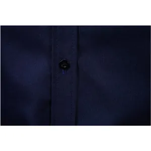 Detailed close-up of navy blue men's dress shirt with black button and fine stitching.