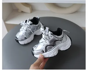 Dettaglio ravvicinato di sneaker per bambini argento metallizzato con suola bianca spessa