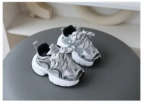 Dettaglio delle sneakers in pelle metallizzata argento per bambini con suole bianche spesse