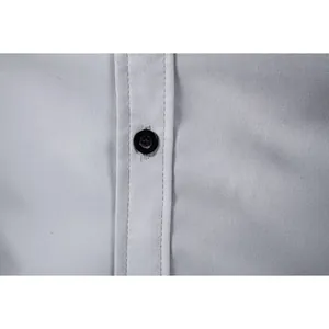 Close-up detail of a grey business casual shirt with a black button and fine stitching