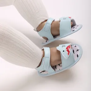 Detailed close-up of light blue baby sandals with cute cartoon shark face design