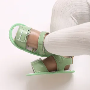 Detail shot of green cartoon dinosaur baby sandals with soft soles for infants