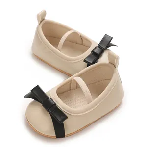 Elegant cream baby girl Mary Jane princess shoes featuring decorative black bow accents