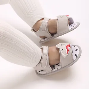 Close-up of baby walking sandals with cartoon shark design and soft sole on foot
